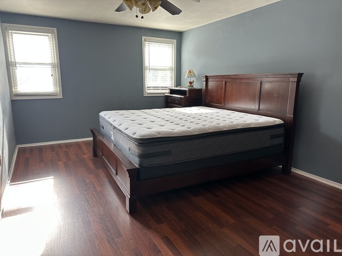 A bedroom with a large bed and a ceiling fan.