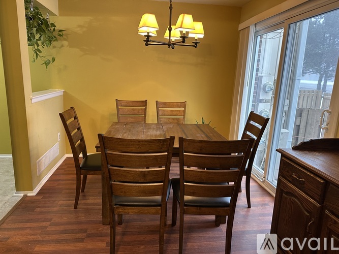 A dining room with a wooden table and chairs.