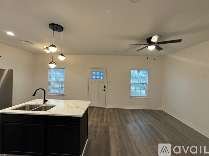A kitchen with a sink and a fan on the ceiling.