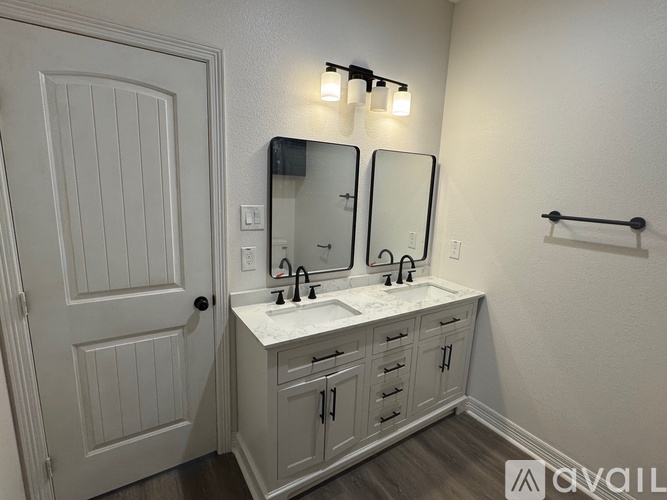 A bathroom with a white vanity and a white door.