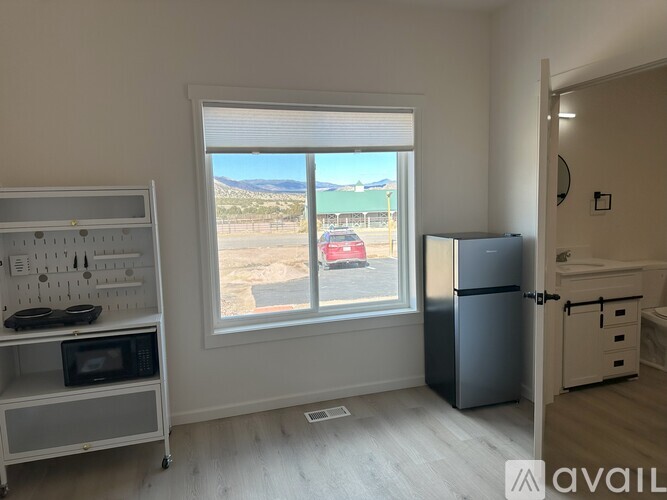 A kitchen with a window overlooking a parking lot.