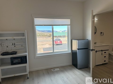 A kitchen with a window overlooking a parking lot.