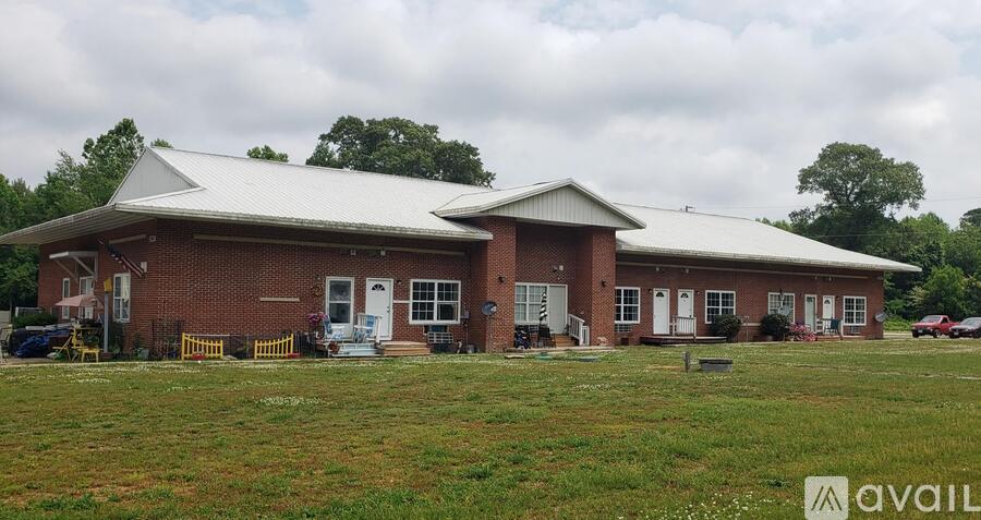 A house with a grey roof and a sign that says "available" in front of it.