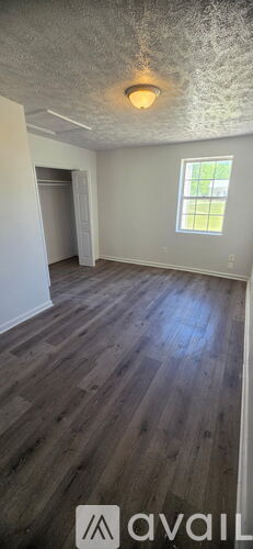 A room with wooden flooring and a window.