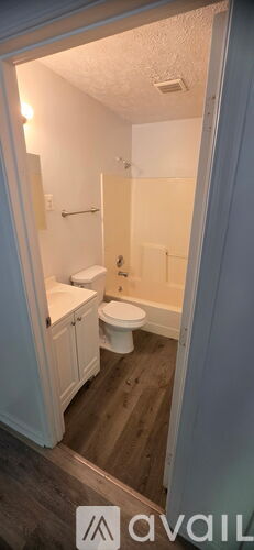A bathroom with a toilet, sink, and bathtub.
