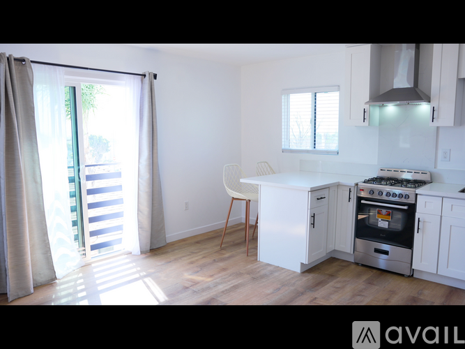 A kitchen with white cabinets and a stove top oven.