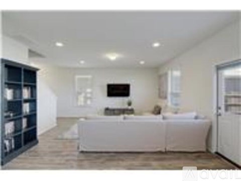 A modern living room with a white sofa and a television.