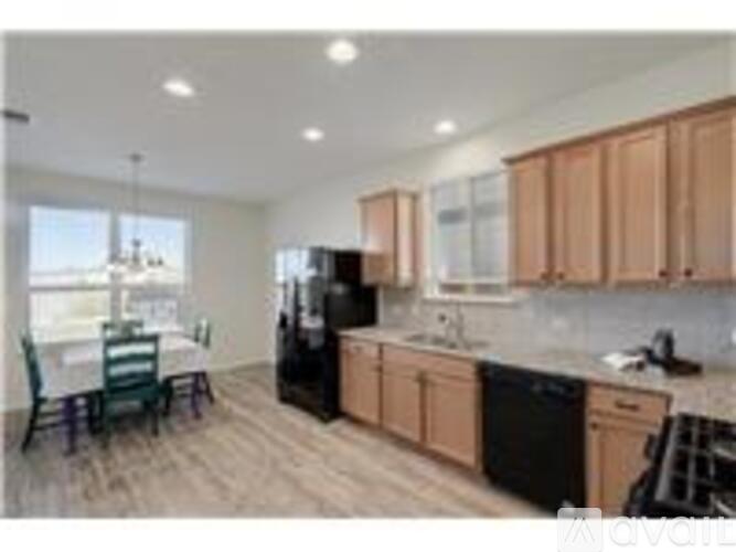 A kitchen with wooden cabinets and black appliances.