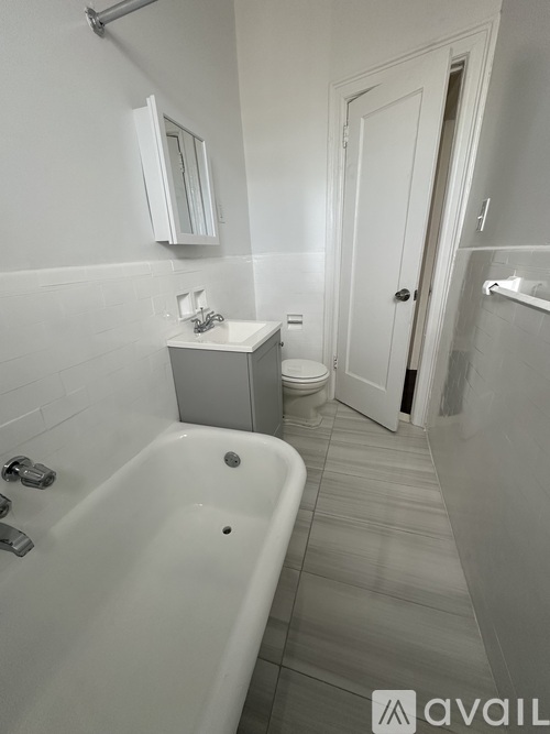 A bathroom with a tub, sink, and toilet.