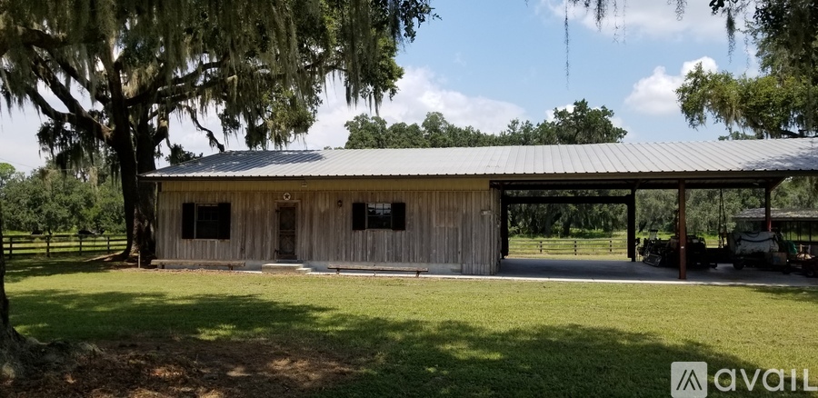 A barn with a metal roof and a sign that says "AVAIL" in the foreground.