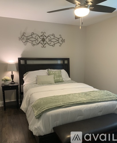A bedroom with a large bed and a ceiling fan.