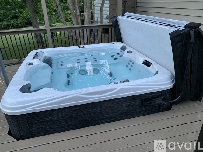 A hot tub is covered with a white cover and is placed on a wooden deck.