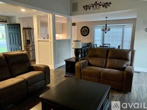 A living room with two brown leather chairs and a black coffee table.