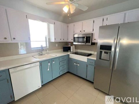 A kitchen with white cabinets and a stainless steel refrigerator.