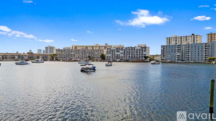 A body of water with boats and buildings in the background.