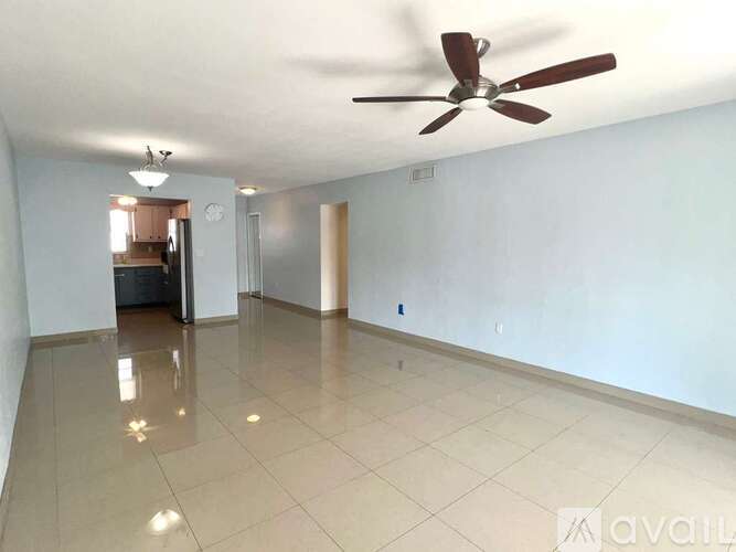 A spacious room with a ceiling fan and tiled floor.