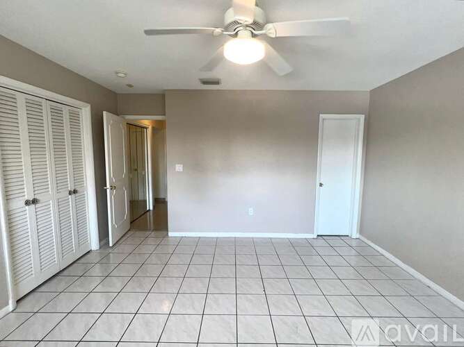 A room with a ceiling fan and tile flooring.