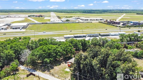 An aerial view of an airport with a runway and several buildings.