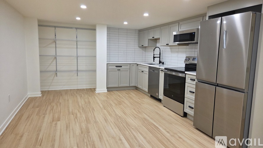 A kitchen with a refrigerator, oven, and microwave.
