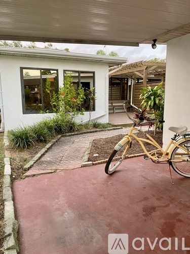 A yellow bicycle is parked on a red brick path.
