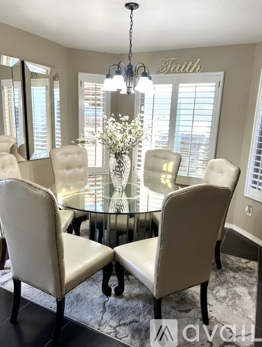 A dining room with a glass table and chairs.
