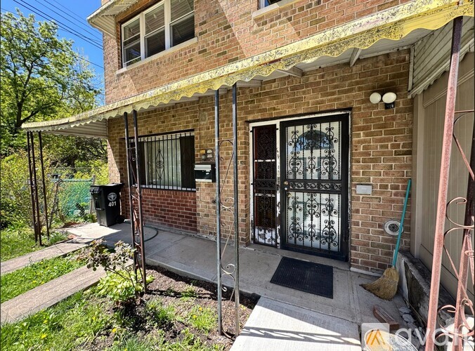 A brick house with a black gate and a small porch.