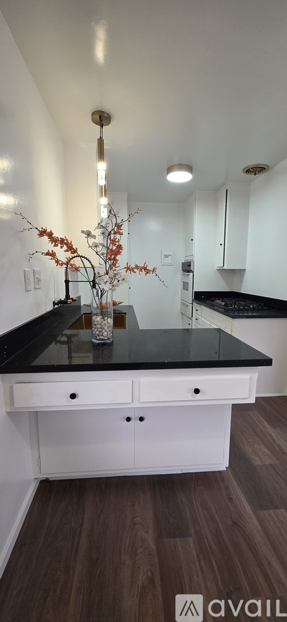 A kitchen with a black counter top and white cabinets.