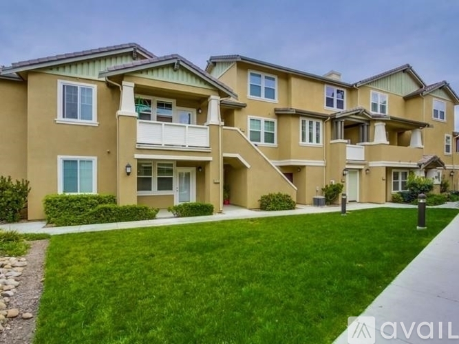 Apartment building with a lawn in front and a sidewalk.