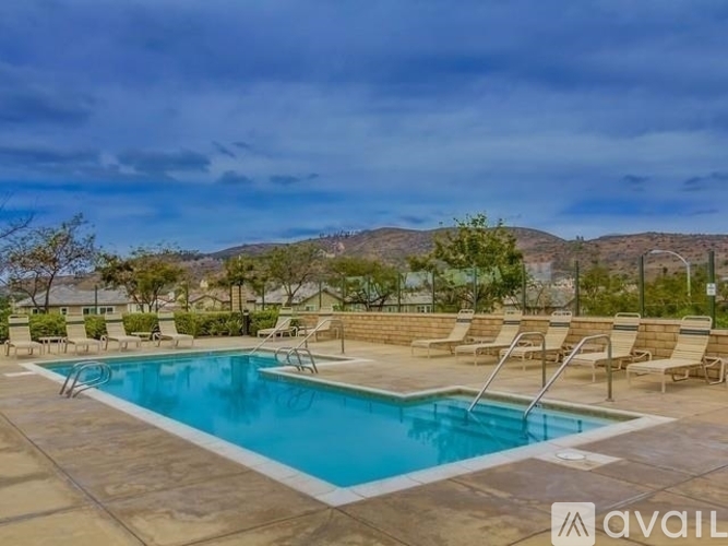 A large outdoor swimming pool surrounded by lounge chairs.