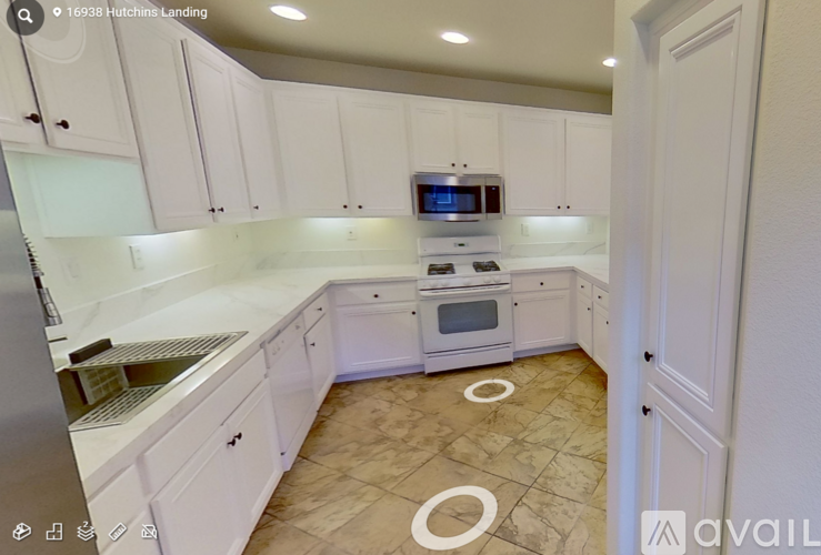 A kitchen with white cabinets and a tiled floor.