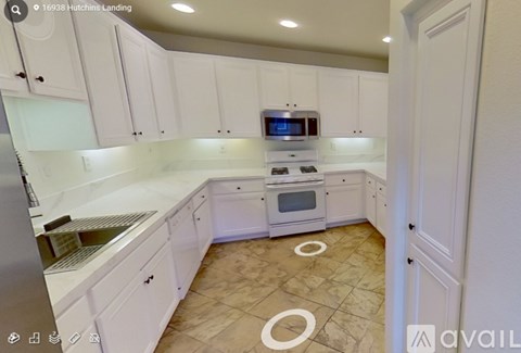 A kitchen with white cabinets and a tiled floor.