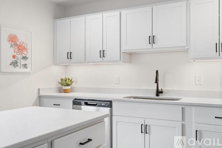 A kitchen with white cabinets and a white countertop.