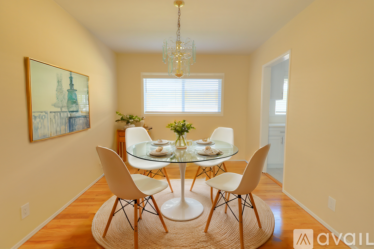 A dining room with a white table and chairs.
