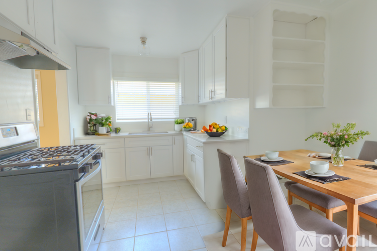 A kitchen with a table and chairs.