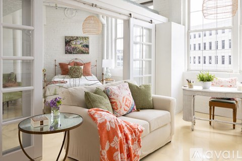 A living room with a white couch and a glass table.