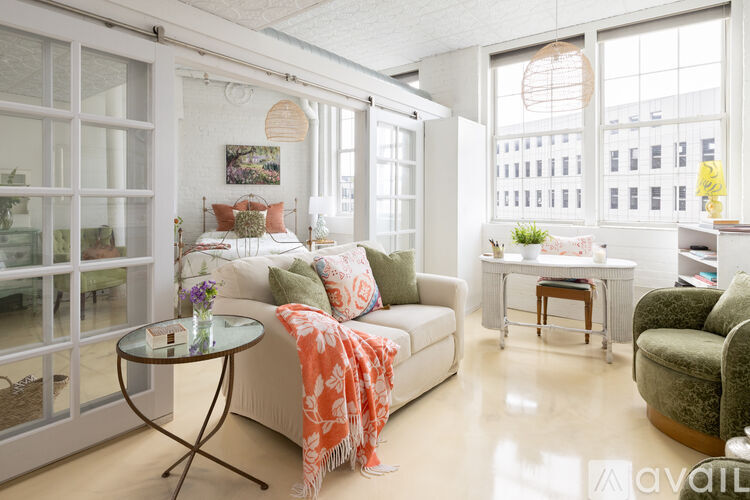 A living room with a white couch and a glass table.