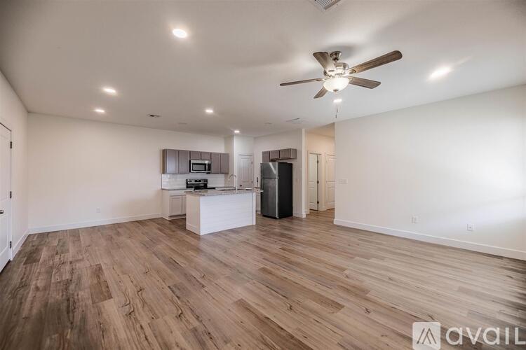 A spacious room with wooden flooring and a ceiling fan.