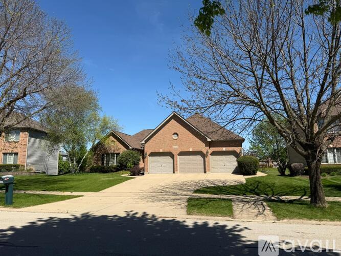 A house with a driveway and trees in front.