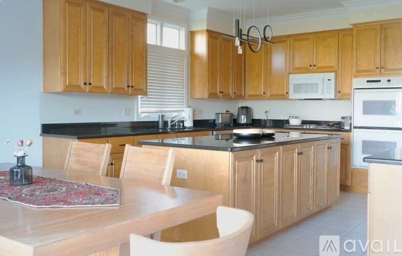 A kitchen with wooden cabinets and a black countertop.