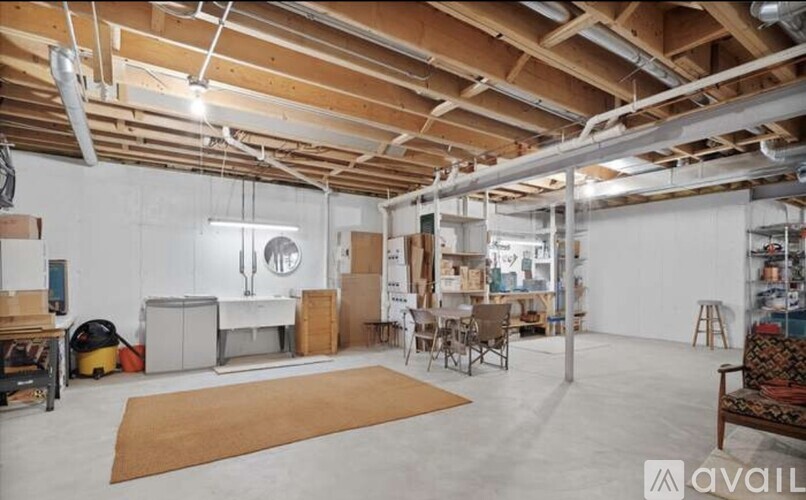 A spacious room with a high ceiling and exposed pipes.