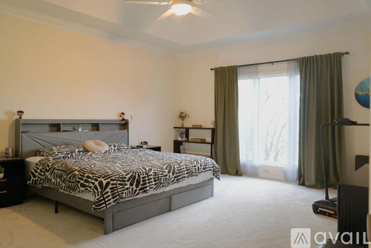 A bedroom with a large bed and a ceiling fan.