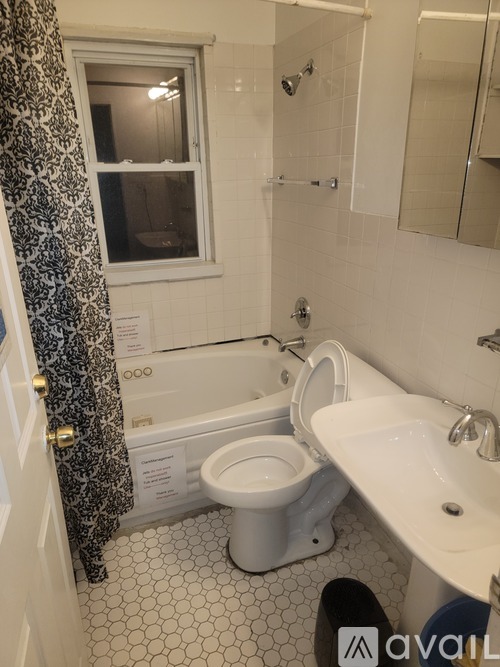 A bathroom with a toilet, sink, and shower.
