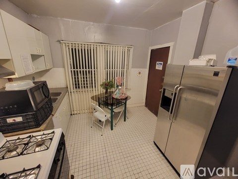 A kitchen with a stove, refrigerator, and a table with chairs.
