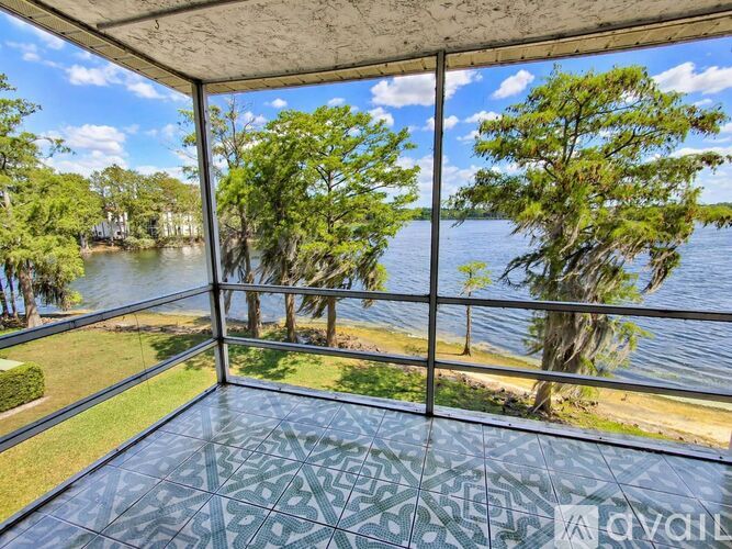 A balcony with a view of a lake and trees.