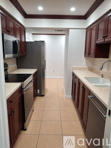 A kitchen with brown cabinets and a white counter top.