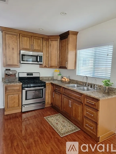 A kitchen with wooden cabinets and a black stove top oven.