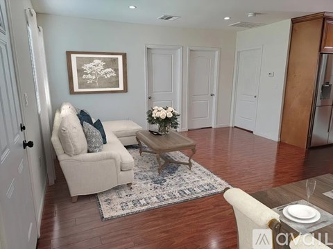 A living room with a couch, coffee table, and a painting on the wall.