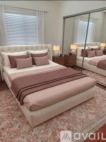 A bedroom with a large bed and a mirror on the wall.