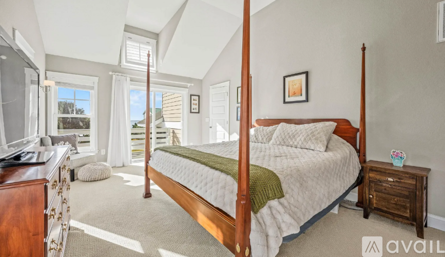 A bedroom with a large bed and a dresser.