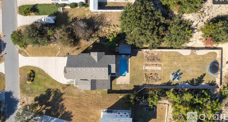 A bird's eye view of a house with a pool and a car parked in front.
